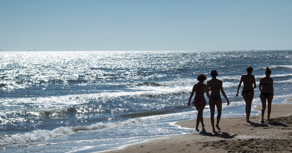 Mennesker som går på en strand.Foto.