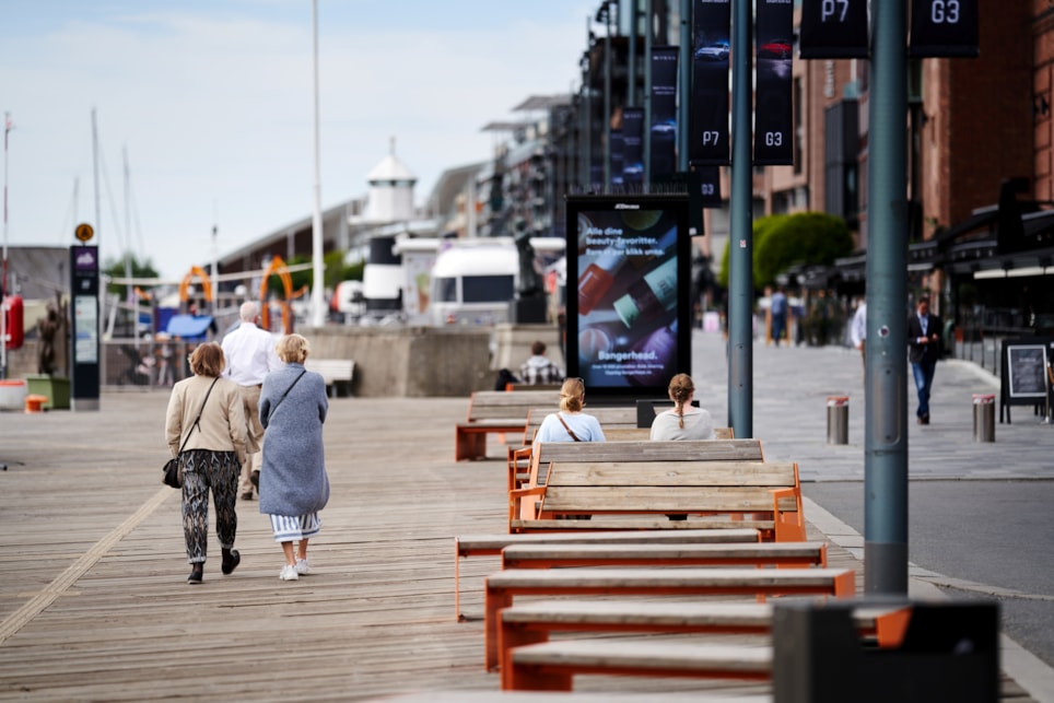 Lite folk på Aker brygge i Oslo på en kald sensommer-dag. Foto.